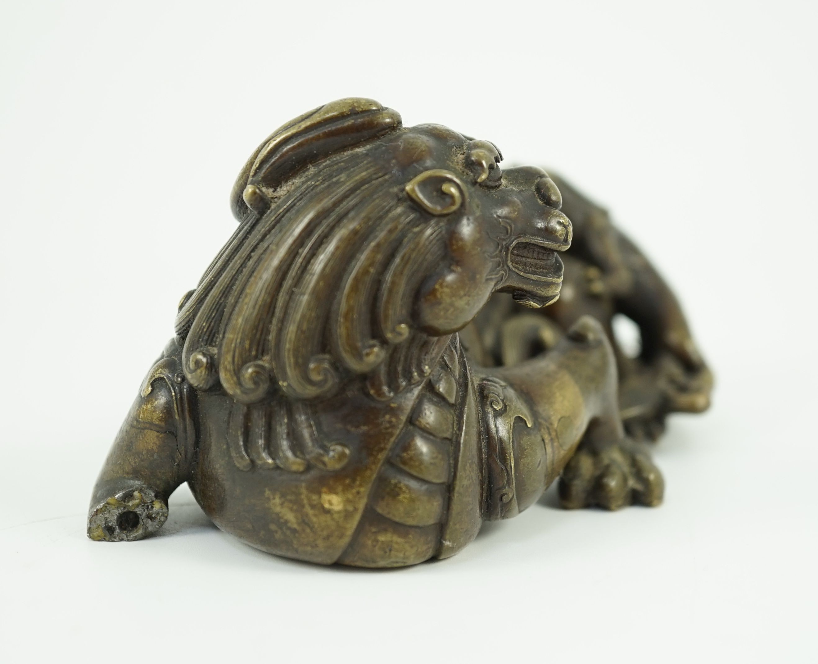 A finely cast Chinese bronze lion-dog and cub scroll weight, 17th/18th century, 14cm long, one foot and a cub lacking